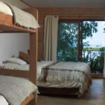 Habitación con 2 camas individuales de 1 1/2 plaza + 2 literas. Incluye desayuno frente al Lago Cucao, baño privado, calefacción y WIFI.
